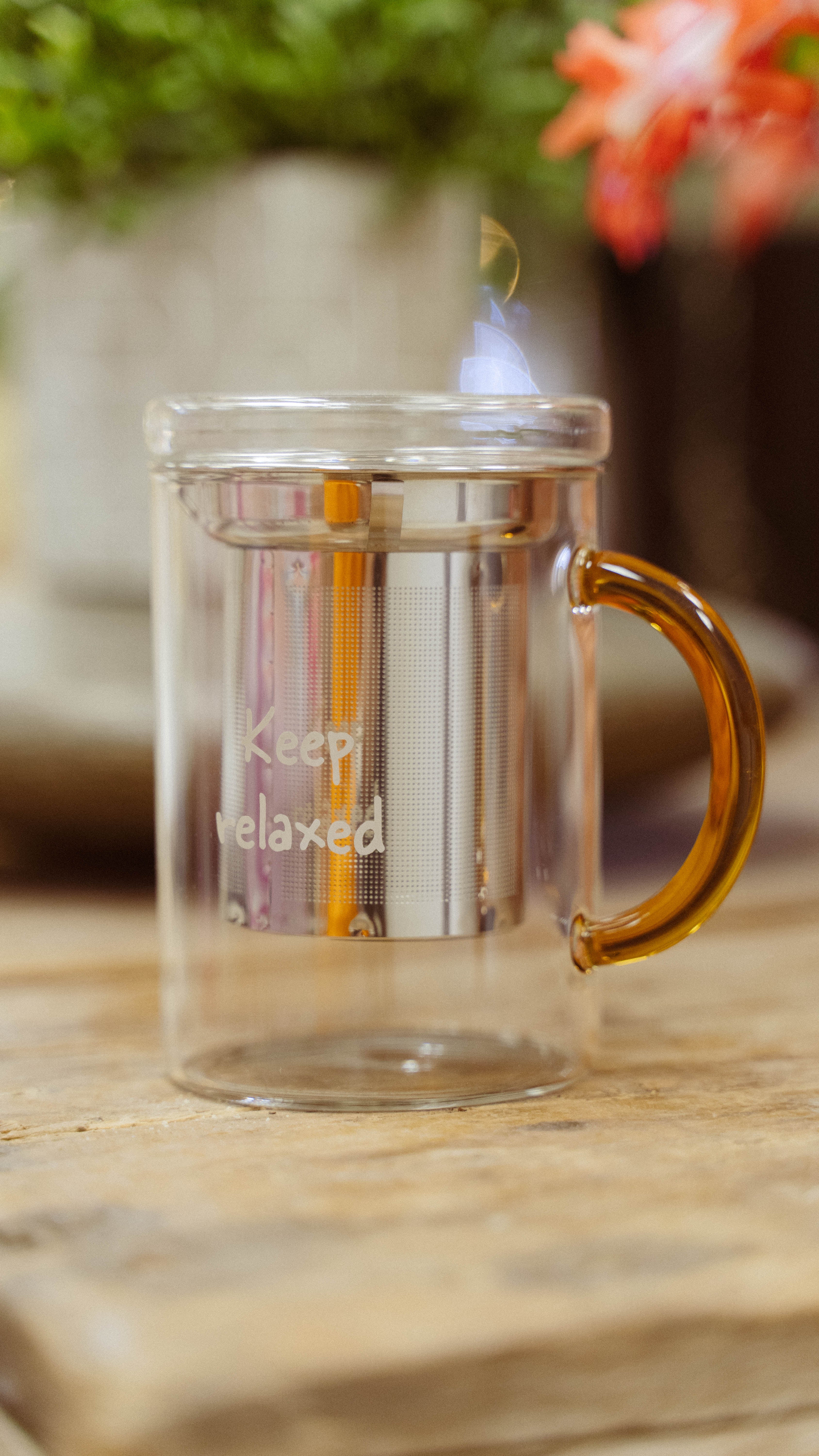 Tisaniera in vetro borosilicato con filtro in acciaio inox, manico colorato e scritta decorativa Keep relaxed Arancione